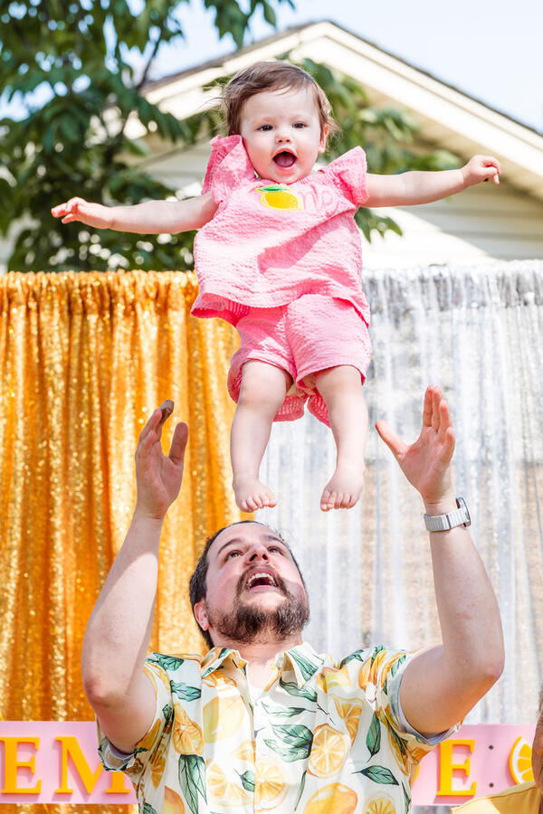 Untitled Baby - 1 year old smiling as she's tossed into air by dad