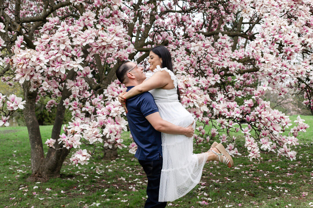 Untitled Couple - man lifting woman in front of a blossom tree