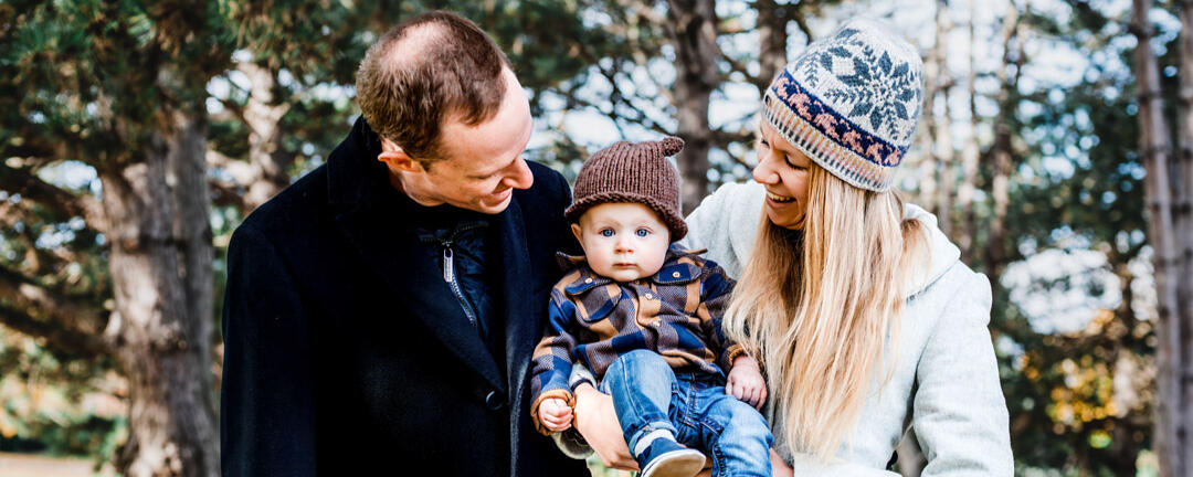mother and father smiling looking at their 5 month son